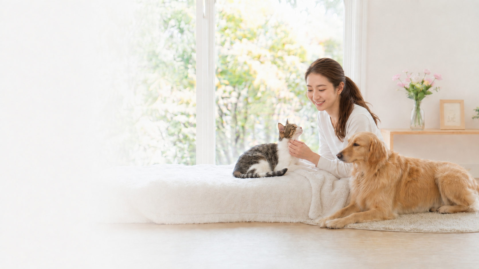 猫と犬にやさしく触れる女性
